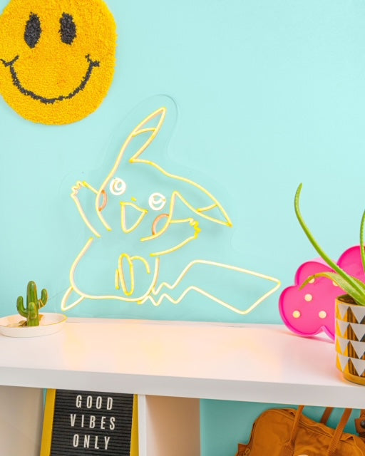 Yellow Pikachu LED neon sign on top of a white desk